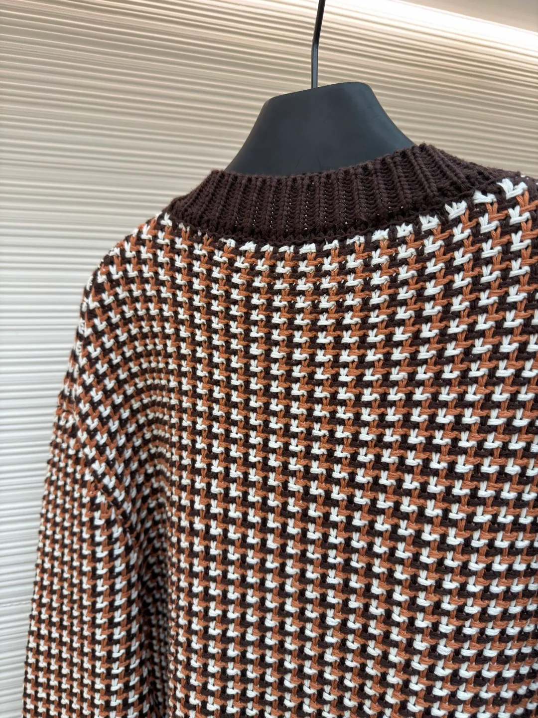 LOUIS VUITTON Thick needle houndstooth color block jacquard pearl button knitted cardigan ●Item number: 1682237-B95 ●Material: wool blended fabric ●Technology: knitted jacquard production ●Color: pattern ●Version: fitted version ●Weight: about 1220 grams ●Size: S-M-L-XL ●Description: This houndstooth knitted cardigan is woven with worsted wool blended yarn. It uses double-ply threading technology to make the yarn tighter. It uses yarn-dyed jacquard technology to create a classic houndstooth pattern. The pattern is clear and symmetrical, with natural color transitions and is not easy to fade. The body of the garment uses a four-knit knitting process. The fabric has high density, good elasticity, and good warmth retention and anti-pilling properties. The neckline, cuffs and hem are designed with ribbed edges and are made of high-elastic spandex blended ribs, which will not easily loosen and deform after long-term wear. The placket is equipped with matte mother-of-pearl buttons, which are hand-polished and polished for a warm texture. The overall design adopts three-dimensional tailoring, and the stitching between the shoulders and body uses embedded clip technology. The stitching is smooth and has no bulges. The spacing of each stitch is precisely controlled, and the exquisite knitting craftsmanship and ingenuity are displayed in every detail. The overall wiring is straight and delicate, the fabric is comfortable and soft, and the color is consistent without color difference. It can be matched with the same style to create a fashionable look and control various occasions. Customized accessories, complete with three standards, same style for men and women!